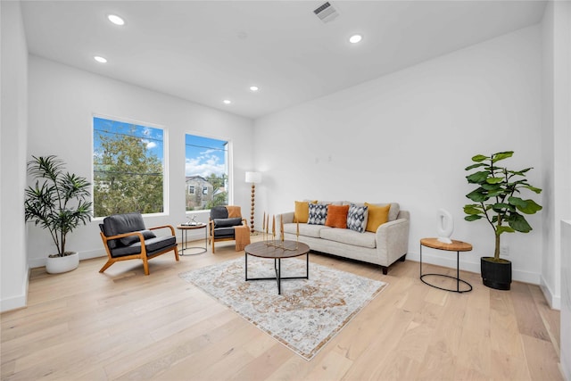 living area featuring light wood-style floors, baseboards, visible vents, and recessed lighting