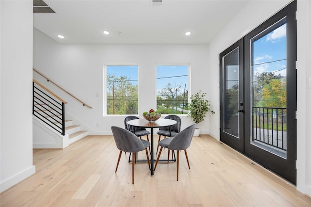 dining space featuring light wood finished floors, baseboards, stairway, and recessed lighting