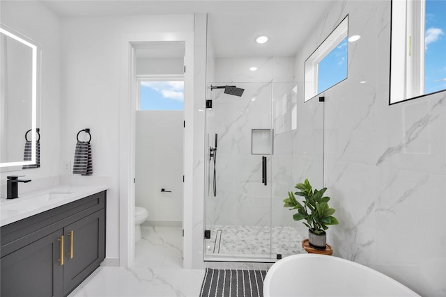 bathroom featuring toilet, vanity, marble finish floor, a soaking tub, and a marble finish shower