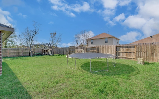 view of yard with a playground and a trampoline