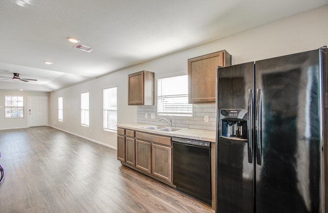 kitchen with a wealth of natural light, ceiling fan, sink, backsplash, and black appliances