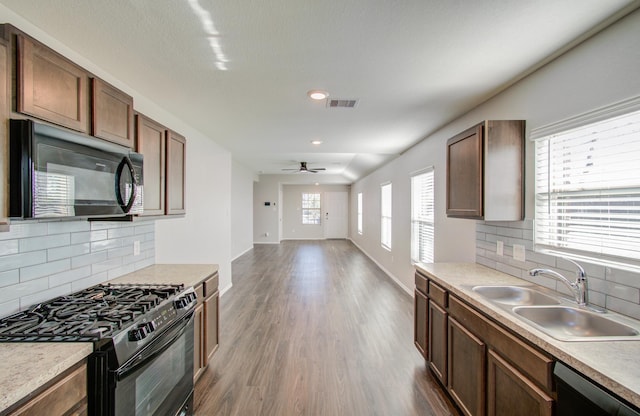 kitchen featuring decorative backsplash, sink, ceiling fan, and black appliances