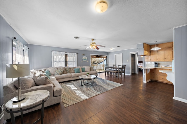 living room with ceiling fan, dark hardwood / wood-style floors, and a textured ceiling