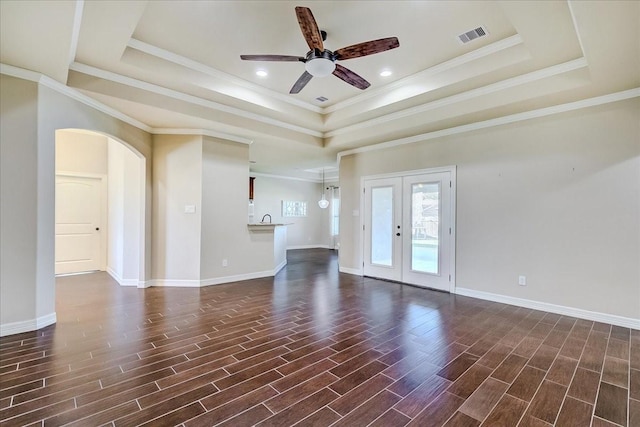 unfurnished room featuring a raised ceiling, crown molding, french doors, and ceiling fan