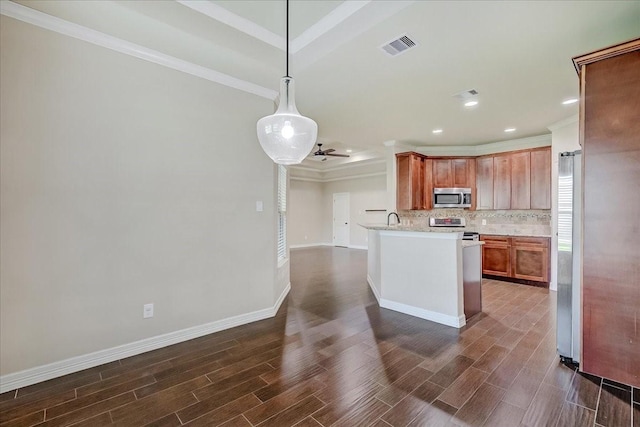 kitchen featuring kitchen peninsula, appliances with stainless steel finishes, tasteful backsplash, ornamental molding, and decorative light fixtures