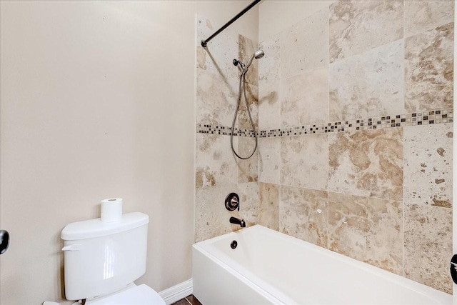 bathroom with toilet and tiled shower / bath