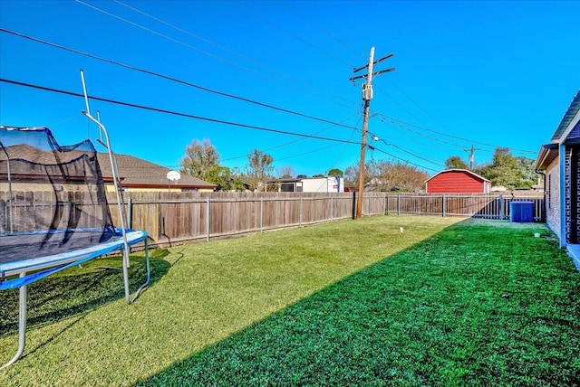 view of yard featuring a trampoline and central air condition unit