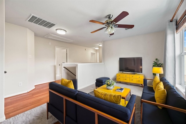 living room featuring ceiling fan, plenty of natural light, and light hardwood / wood-style floors