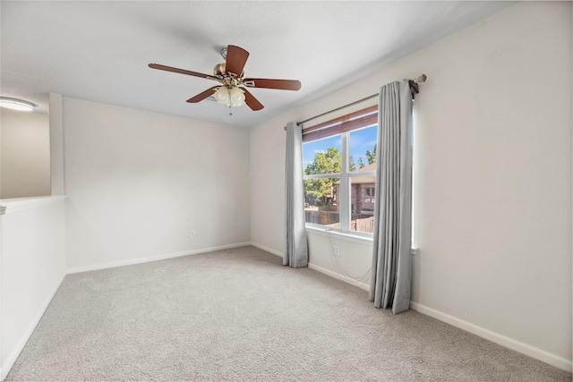 carpeted spare room featuring ceiling fan