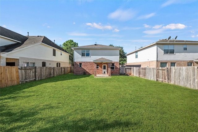 rear view of house featuring a yard