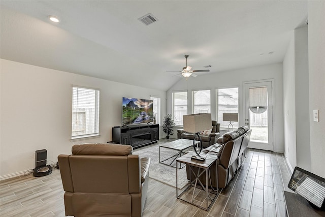 living room featuring ceiling fan, a fireplace, and lofted ceiling