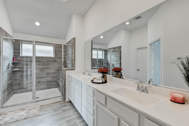 bathroom featuring vanity, walk in shower, and lofted ceiling