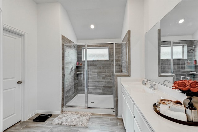 bathroom with vanity, vaulted ceiling, and walk in shower