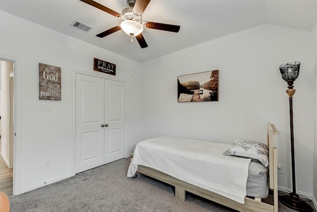 carpeted bedroom featuring ceiling fan, vaulted ceiling, and a closet