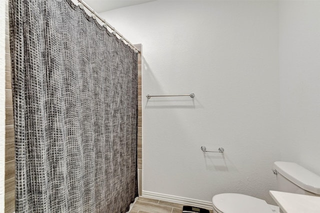 bathroom with curtained shower and toilet