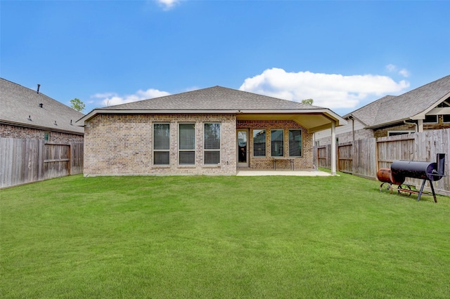 back of property with a yard and a patio