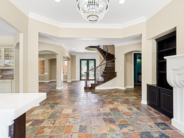 foyer featuring french doors, crown molding, and a notable chandelier