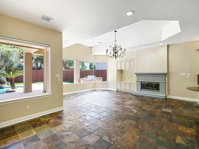 unfurnished living room with a notable chandelier and a tile fireplace