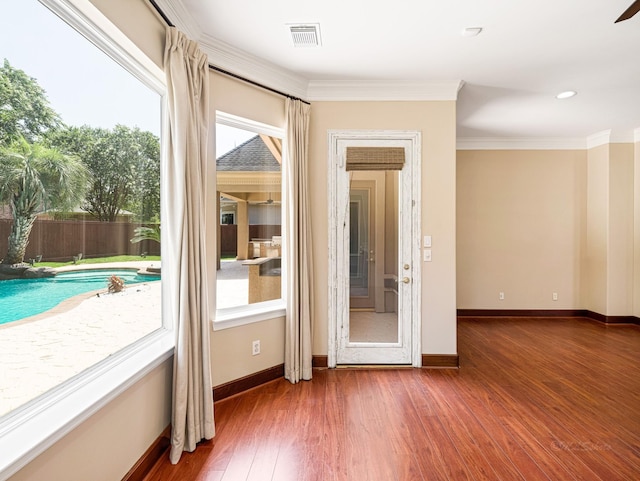 entryway featuring crown molding, dark wood-type flooring, and a healthy amount of sunlight