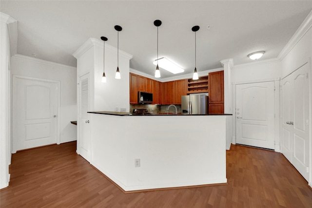 kitchen featuring decorative backsplash, stainless steel refrigerator with ice dispenser, dark hardwood / wood-style flooring, crown molding, and hanging light fixtures