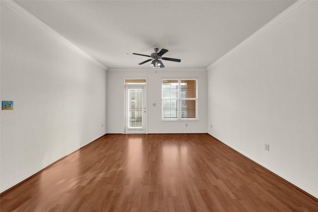 spare room with wood finished floors, a ceiling fan, and crown molding