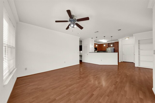 unfurnished living room with built in shelves, crown molding, dark hardwood / wood-style flooring, and ceiling fan