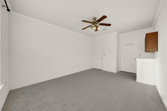 carpeted empty room featuring ornamental molding, visible vents, and a ceiling fan