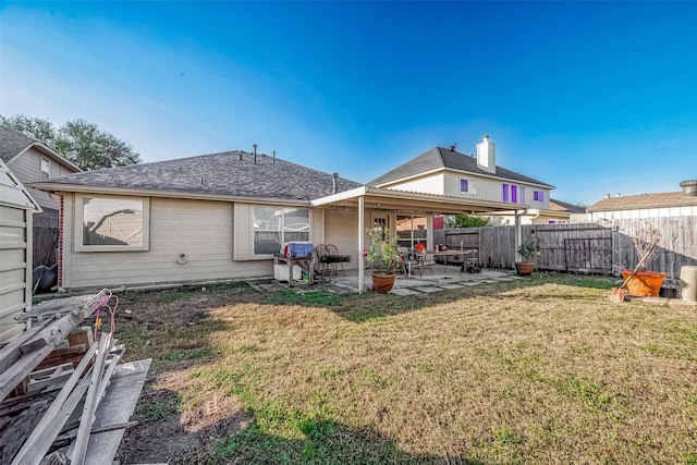 back of property with a yard and a patio