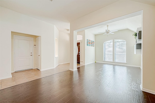 spare room with ceiling fan, light hardwood / wood-style floors, and vaulted ceiling