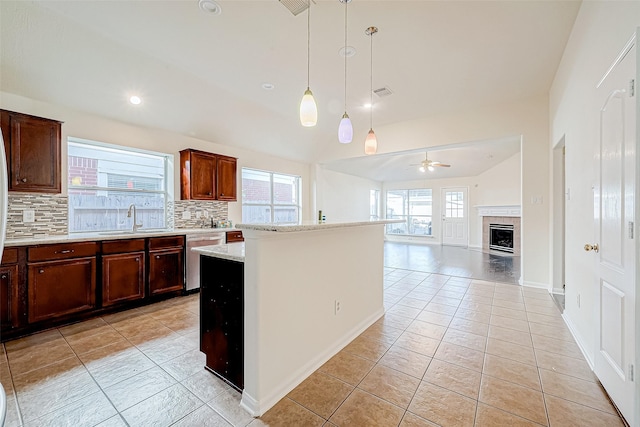 kitchen featuring ceiling fan, light tile patterned floors, tasteful backsplash, decorative light fixtures, and a kitchen island