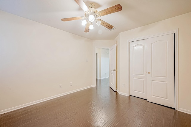 unfurnished bedroom with ceiling fan, wood-type flooring, and a closet