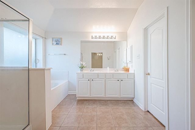 bathroom featuring tile patterned flooring, vanity, and a tub to relax in