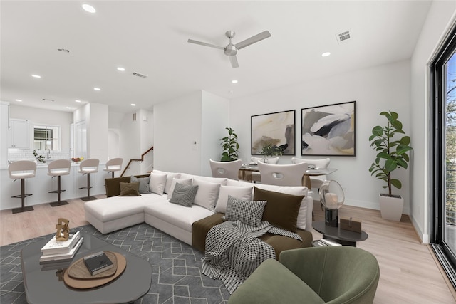 living room with ceiling fan and light wood-type flooring