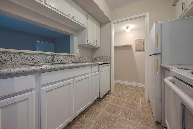 kitchen featuring white cabinetry, stove, dishwasher, light stone countertops, and sink