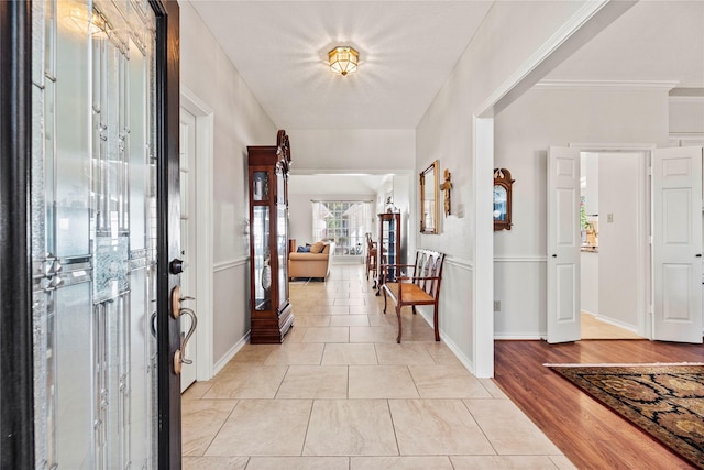 tiled entrance foyer featuring crown molding