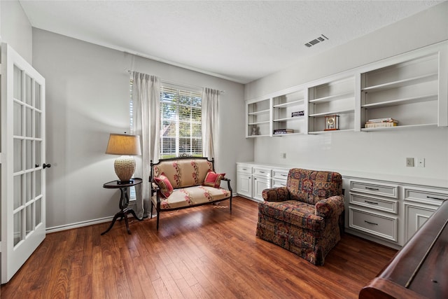 living area featuring dark wood-type flooring and a textured ceiling