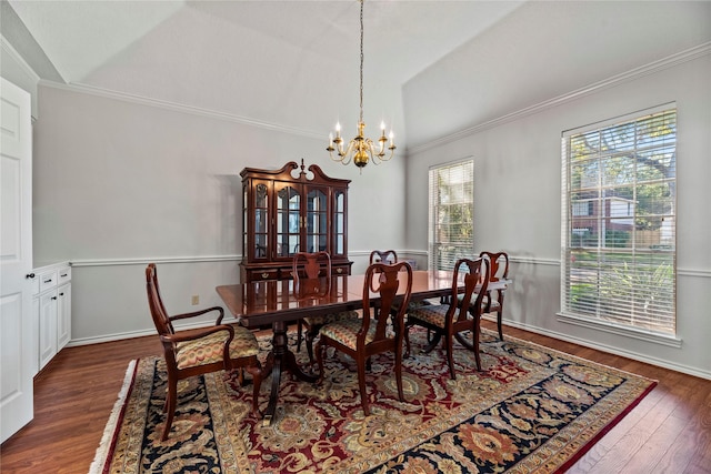 dining area featuring ornamental molding, dark wood-type flooring, lofted ceiling, and a notable chandelier