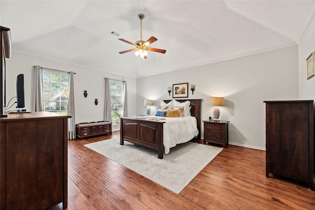 bedroom featuring ceiling fan, ornamental molding, dark wood-type flooring, and vaulted ceiling