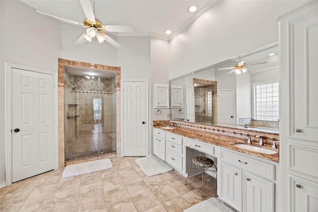 bathroom with crown molding, vanity, a shower with shower door, and ceiling fan