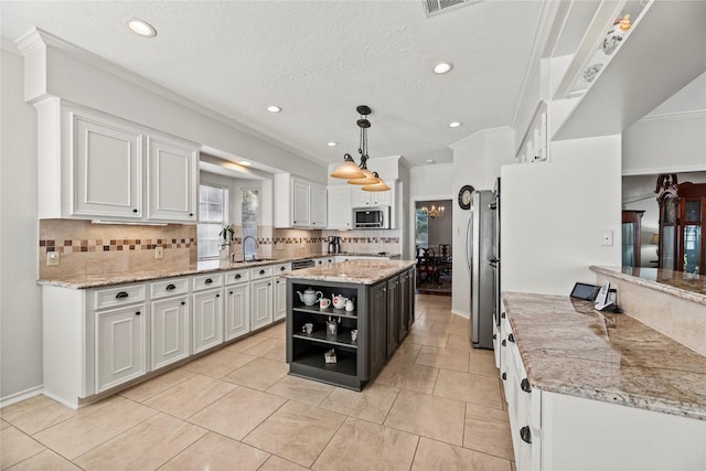 kitchen with pendant lighting, a center island, white cabinetry, and backsplash