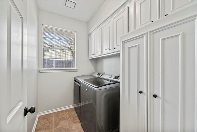 washroom with cabinets, washing machine and dryer, and light tile patterned floors