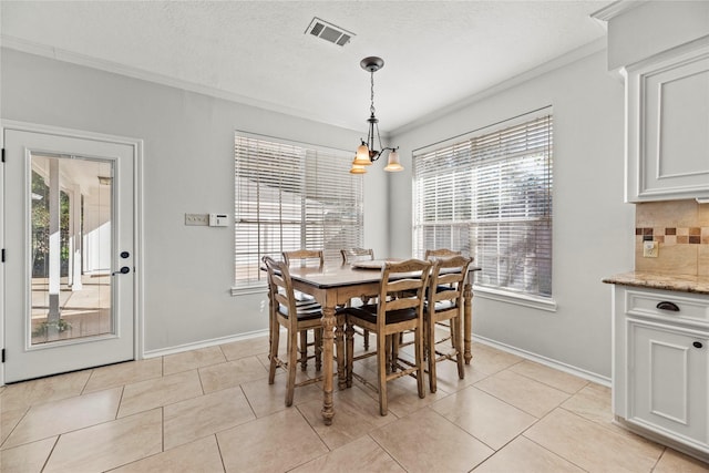 dining space featuring light tile patterned flooring, crown molding, a wealth of natural light, and a chandelier