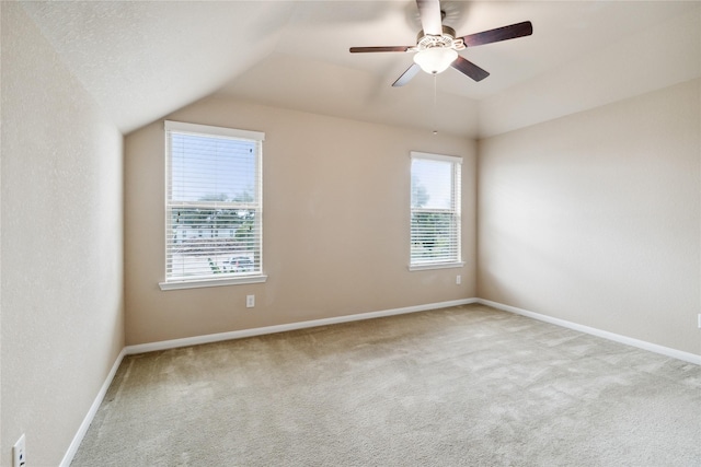 spare room featuring ceiling fan, light carpet, and lofted ceiling