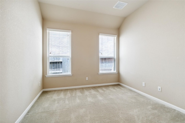 carpeted empty room with vaulted ceiling and plenty of natural light