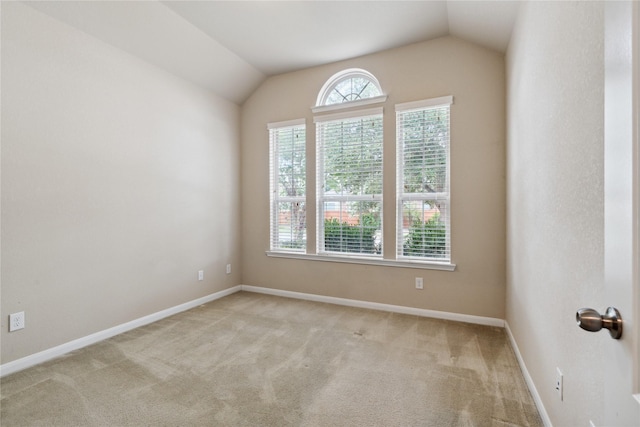 carpeted empty room featuring lofted ceiling