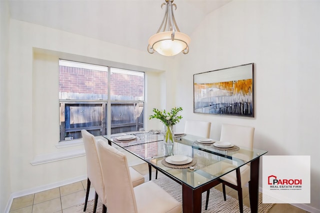 dining room featuring vaulted ceiling and light tile patterned flooring