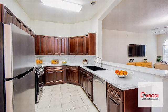 kitchen featuring kitchen peninsula, sink, light tile patterned flooring, light stone countertops, and stainless steel appliances