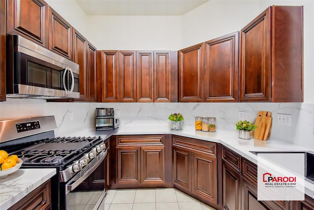 kitchen with light tile patterned floors, decorative backsplash, light stone counters, and stainless steel appliances