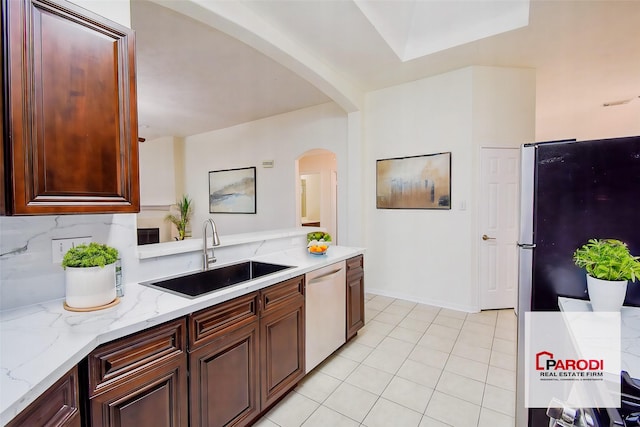 kitchen featuring light tile patterned floors, stainless steel appliances, tasteful backsplash, light stone countertops, and sink