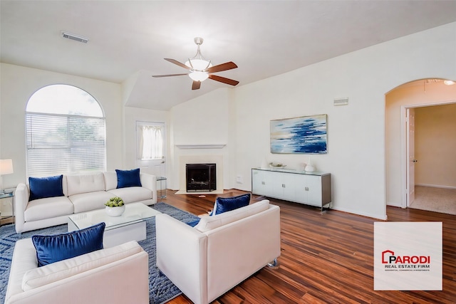 living room with ceiling fan, dark hardwood / wood-style floors, and vaulted ceiling